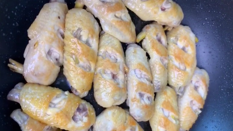 可乐鸡翅,锅中油热下入鸡翅煎至两面金黄