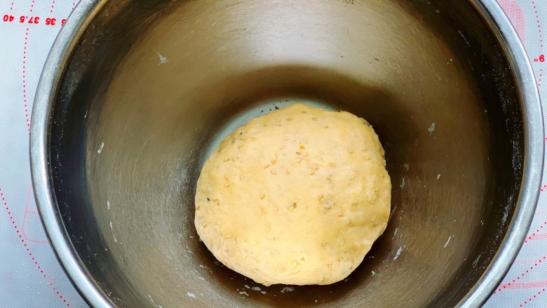 西红柿磨牙棒,再用手揉成光滑的面团，盖上保鲜膜，放在容器里静置醒发30分钟。