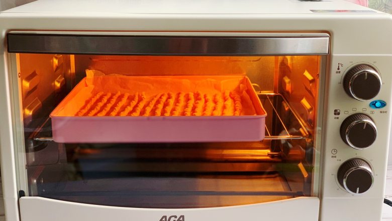 西红柿磨牙棒,放入预热至170度的aca烤箱中层，上下火烘烤25分钟左右，烤至表面金黄色即可。