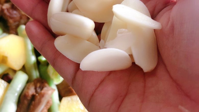 芸豆炖排骨,加入蒜片搅拌均匀,盖盖炖10分钟左右