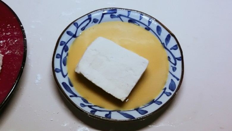 蛋香锅塌豆腐,取一盘子 倒上蛋液 放入<a style='color:red;display:inline-block;' href='/shicai/ 720'>胡椒粉</a>和1克盐 拌匀
把刚刚裹了淀粉的豆腐 再均匀裹上蛋液