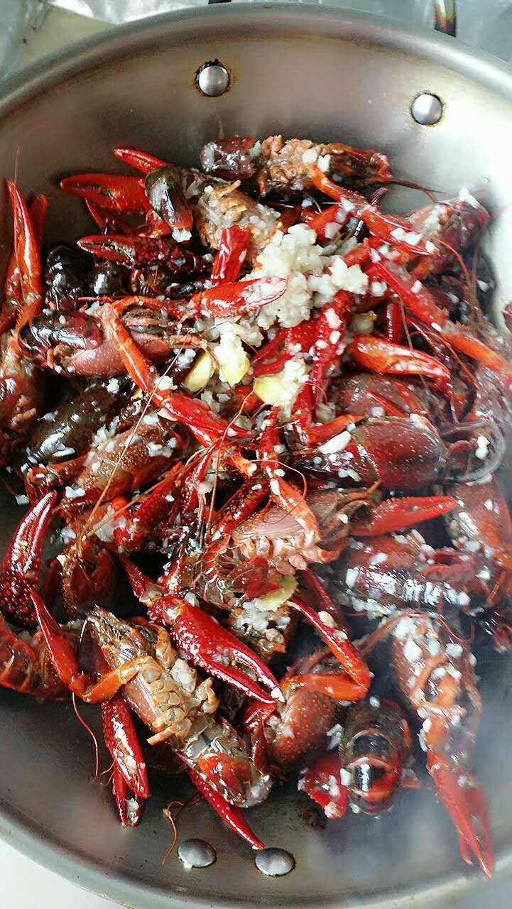 蒜泥小龙虾,倒入小龙虾,生姜,红辣椒,翻炒至虾壳变红,多翻炒一会让虾肉变紧。