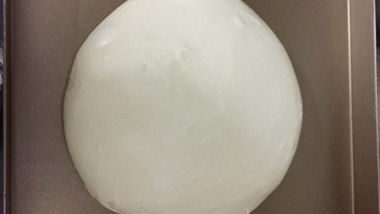 港式肠仔面包,将揉好的面团稍微整圆,放入容器内,盖上保鲜膜进行第一次发酵。发酵温度室温27度,发酵至原来的两倍大。