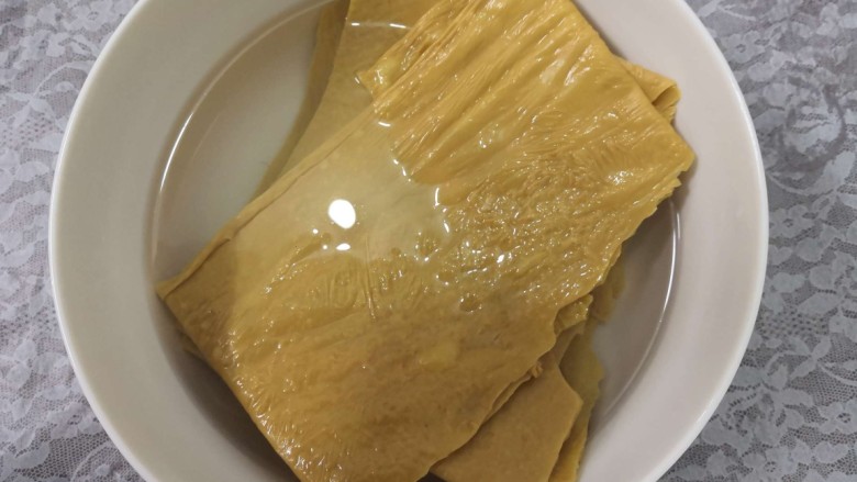 凉拌豆腐皮,把豆腐皮放入碗中,倒入温水,泡软