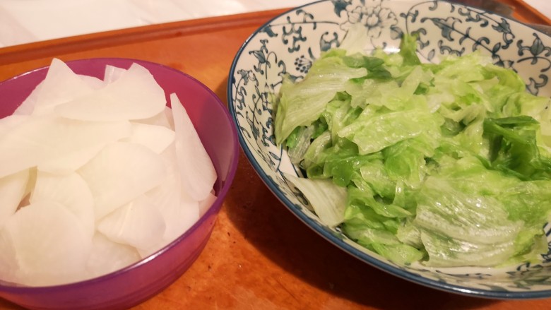 红烧牛肉面,白萝卜切片,生菜撕片,开水烫半熟,备用。