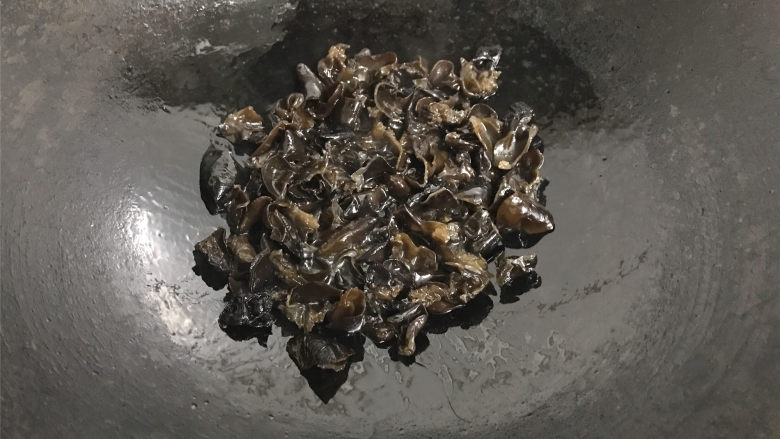 青椒黑木耳炒面筋,锅中倒放适量油,放放黑木耳煸炒。