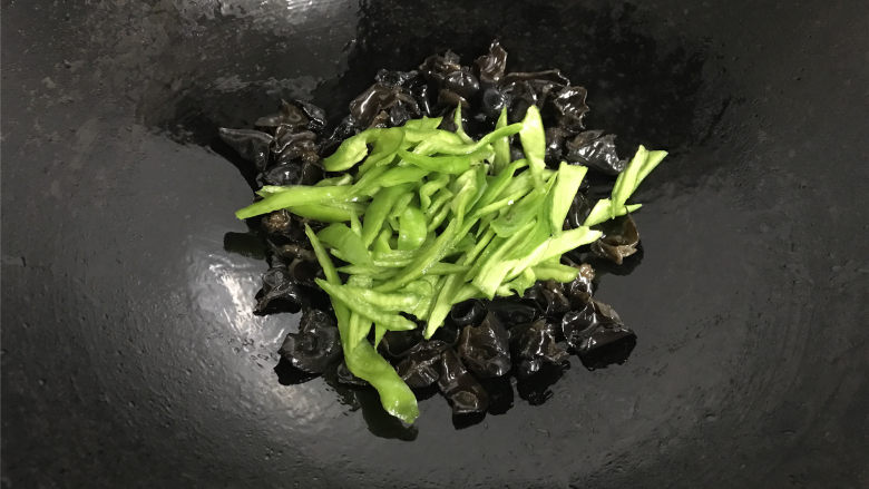 青椒黑木耳炒面筋,再把青椒放入锅中一起翻炒均匀。