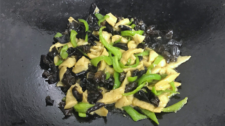 青椒黑木耳炒面筋,翻炒均匀后加入少许水煮开,即可熄火。