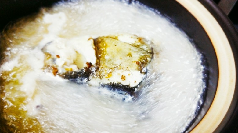 鱼头豆腐,煮沸的汤汁过滤到砂锅中,先大火煮,煮5分钟后再小火慢炖