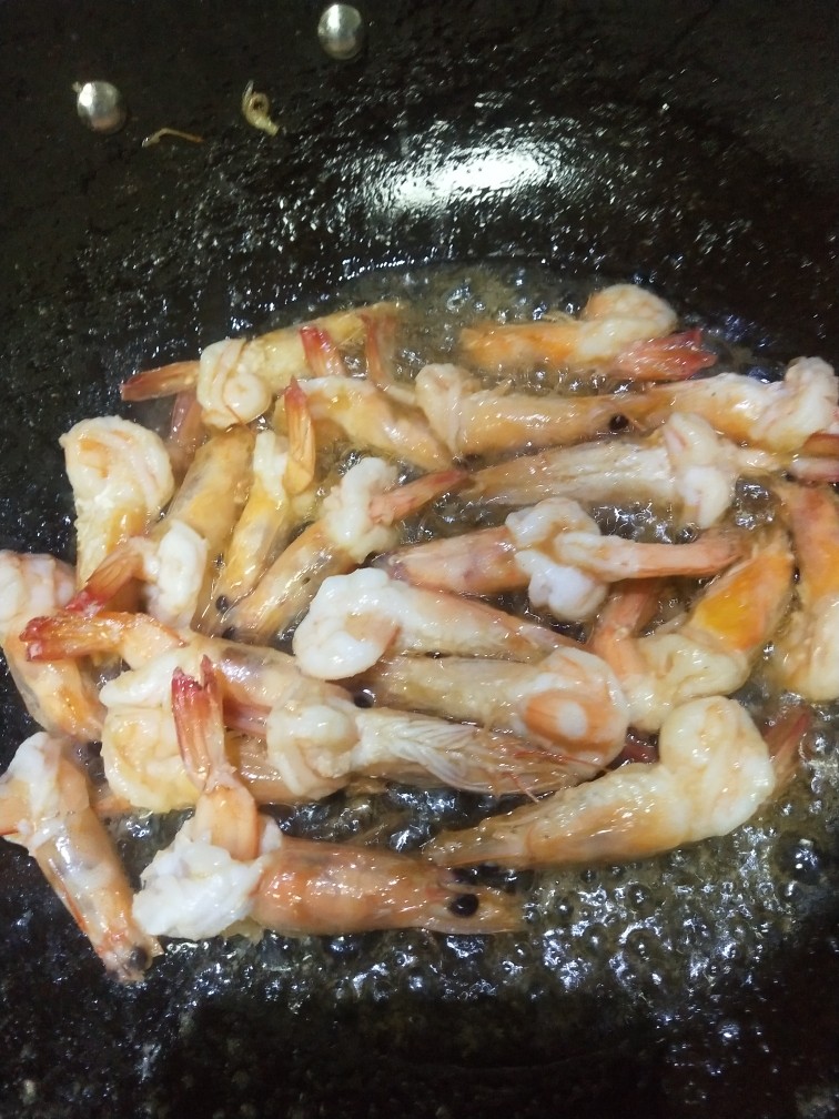 茄汁大虾,剩余的油热后在下入大虾,翻炒,轻敲大虾头部让虾油渗出。变色后加入葱丝,姜丝略炒,倒入少许<a style='color:red;display:inline-block;' href='/shicai/ 718'>料酒</a>翻炒。