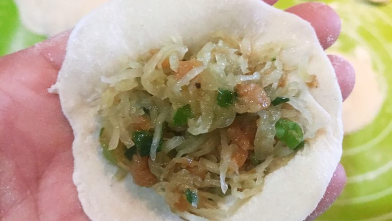 三鲜蒸饺,取一个饺子皮,加入1勺馅料