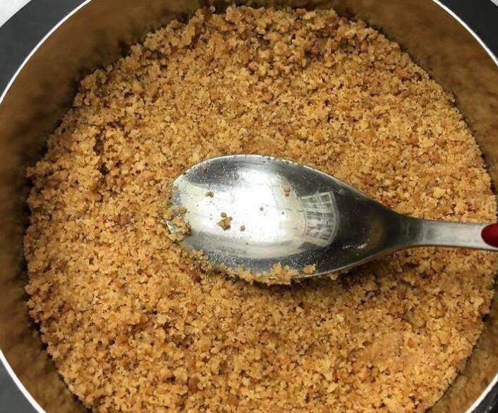 百香芒果双层生乳酪蛋糕(免烤箱),倒入完成的步骤1,用汤匙压密实,压得愈紧密,底部愈不容易碎开。然后放入冰箱冷藏备用。