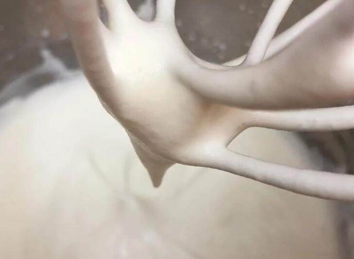 百香芒果双层生乳酪蛋糕(免烤箱),动物性鲜奶油隔冰水搅打至约6分发,流动的浓稠状拉起打蛋器会滴落的状态。