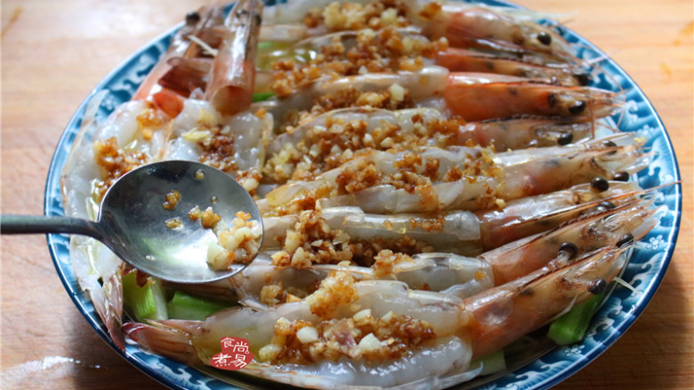 蒜蓉丝瓜蒸海虾,将混合炒香的蒜蓉酱油用汤匙舀起,均匀铺在海虾上面;