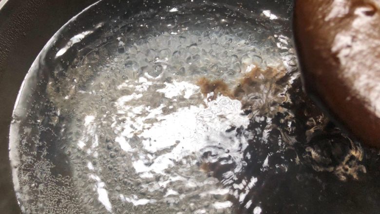 黑凉粉水果捞,取一个没有油的锅,加入2500毫升水,大火把水烧开,再把给黑凉粉糊倒入锅里,记得要一边倒一边快速搅拌,搅拌均匀以后,待水再次煮开就可以关火了。