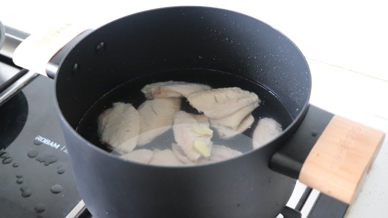 超级下饭菜,可乐鸡翅,把姜片和鸡翅一起放入冷水锅中,加盖烧开。