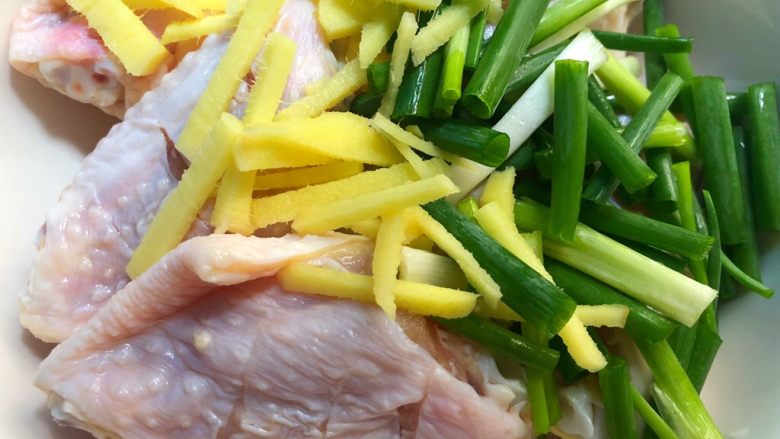 香酥鸡翅,把鸡翅放入碗里,加入生姜和葱段。