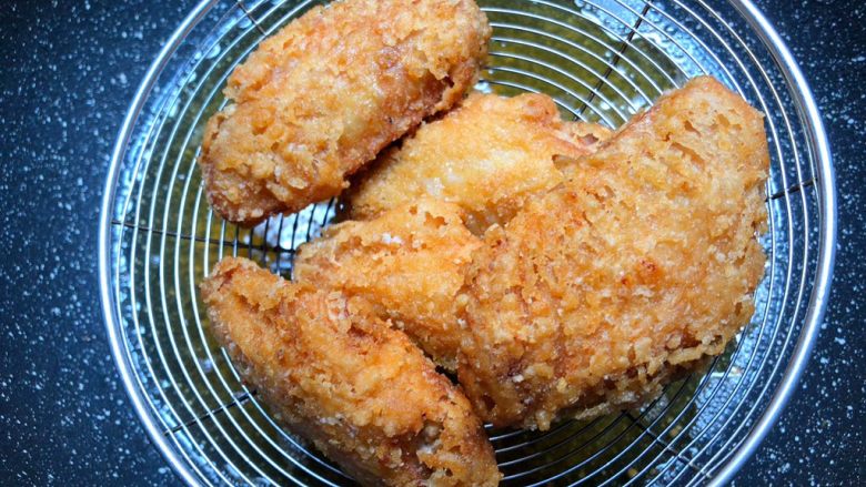 香酥鸡翅,鸡翅炸至酥脆捞起来,等油温升高,再把鸡翅放入炸2分钟,再捞起来控干油。