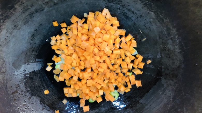 胡萝卜青椒蛋炒饭,起锅烧油,油热后先放葱花爆香,然后放入胡萝卜丁翻炒。