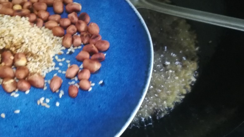 桂花香菇牛肉油辣酱 下饭神器,倒入炒熟的花生米和熟白芝麻,翻炒均匀