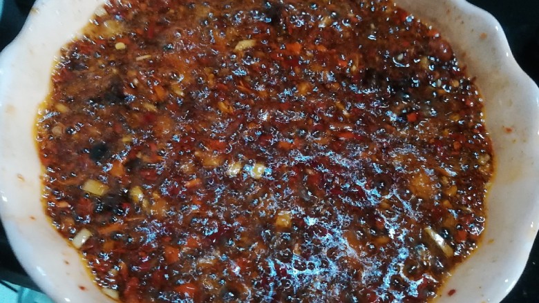 桂花香菇牛肉油辣酱 下饭神器,将留下的一半鸡油分两次加热至开始冒烟,然后趁热倒入辣椒碗,翻拌均匀