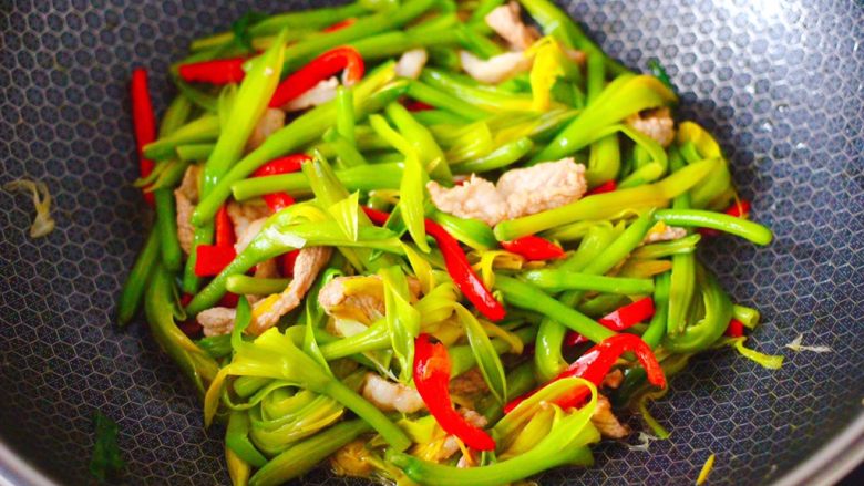 黄花菜炒肉片,大火翻炒至红椒断生变色后,即可关火。
