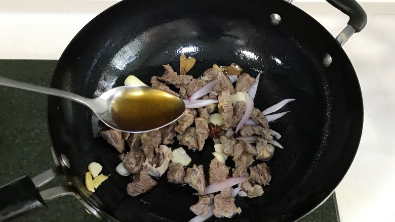 番茄土豆牛腩汤,接着放入1段大葱和<a style='color:red;display:inline-block;' href='/shicai/ 29'>洋葱</a>翻炒片刻,倒入牛腩和1勺料酒翻炒约20秒。