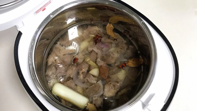 番茄土豆牛腩汤,翻炒好的牛腩放入臻米脱糖电饭煲内,倒入适量的清水,水量要没过食材。