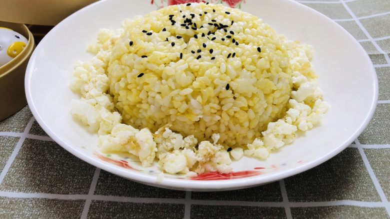 特色黄金蛋炒饭,炒至米饭热透即可,装入盘子中,周围倒入鸡蛋清,米饭上再撒点<a style='color:red;display:inline-block;' href='/shicai/ 668'>黑芝麻</a>,完成!