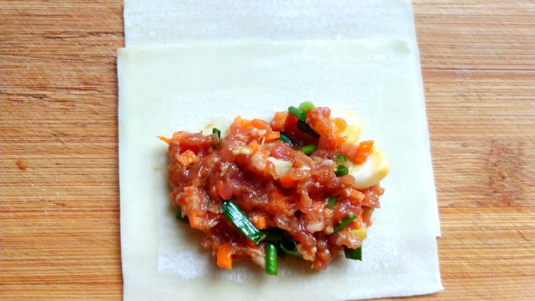 馄饨皮锅贴,取两张<a style='color:red;display:inline-block;' href='/shicai/ 4453'>馄饨皮</a>,放入肉馅。