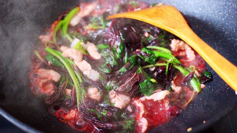 蒜香肉片炒苋菜,锅中看见苋菜断生,汤汁变成红色的时候。