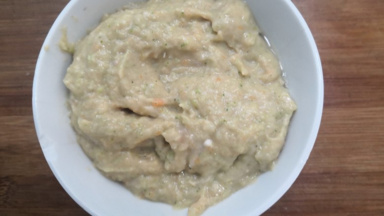 西兰花玉米鸡肉糕,搅打成泥后,倒入碗中,洒入盐,搅拌均匀备用