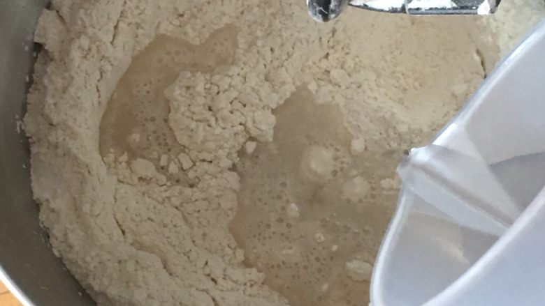 豆沙馅双色扭扭面包,启动厨师机搅拌,倒入清水。