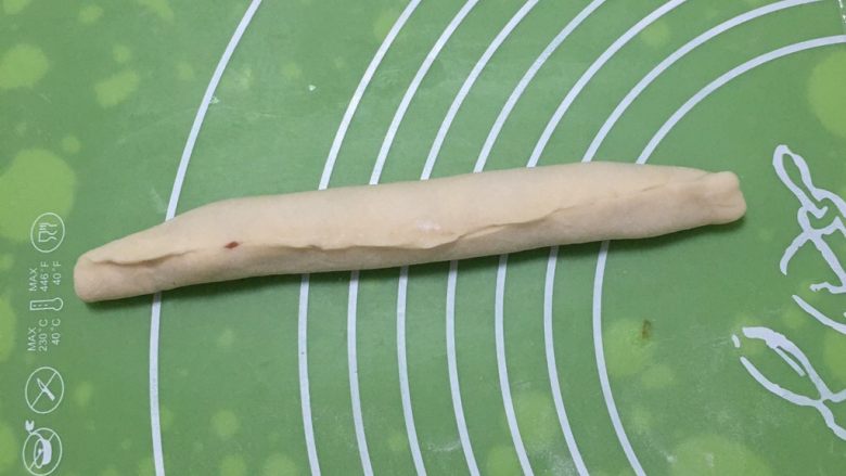 豆沙馅双色扭扭面包,顺势卷起来,收紧口子,再搓成圆柱形。