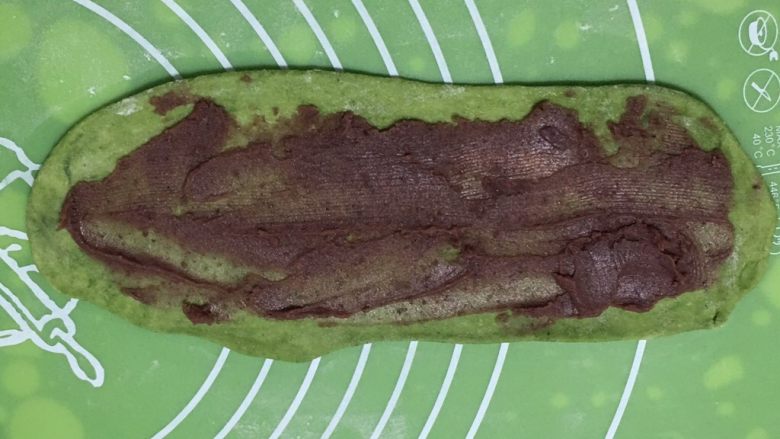 豆沙馅双色扭扭面包,抹茶也擀成椭圆形,铺上豆沙馅儿。