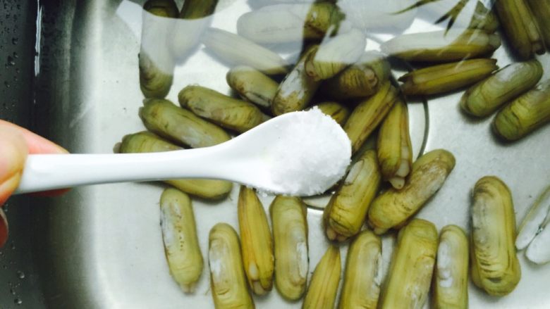 葱油蛏子,将蛏子表面的泥土冲洗干净再加入1小勺盐浸泡两个小时,让蛏子里的泥沙吐干净