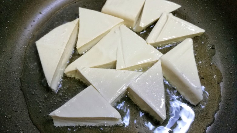 家常豆腐,豆腐入锅煎。