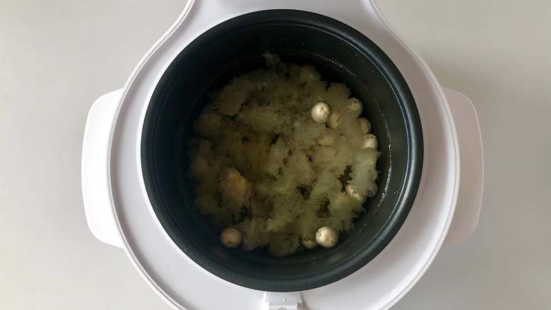 绿豆糯耳莲子汤,把泡好的绿豆和莲子沥水,也放入电饭煲内锅中,加入5倍清水。