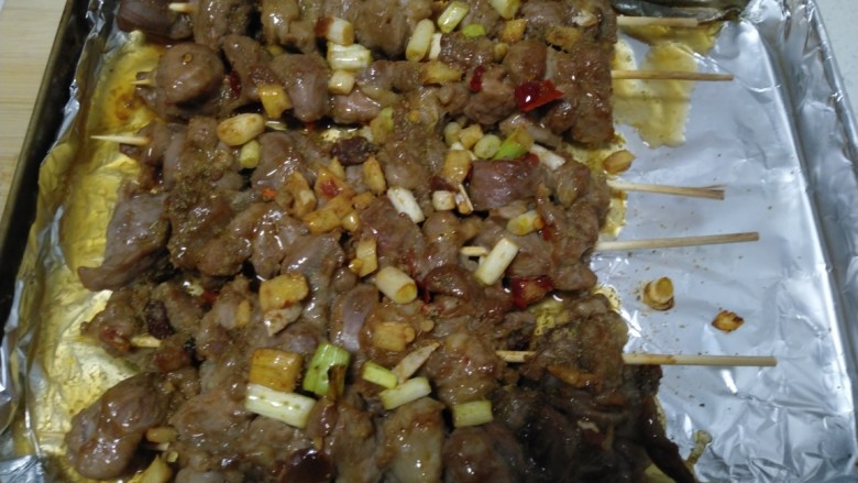 烤羊肉串,取出均匀抹上油,撒上<a style='color:red;display:inline-block;' href='/shicai/ 716'>孜然</a>粉和辣椒。