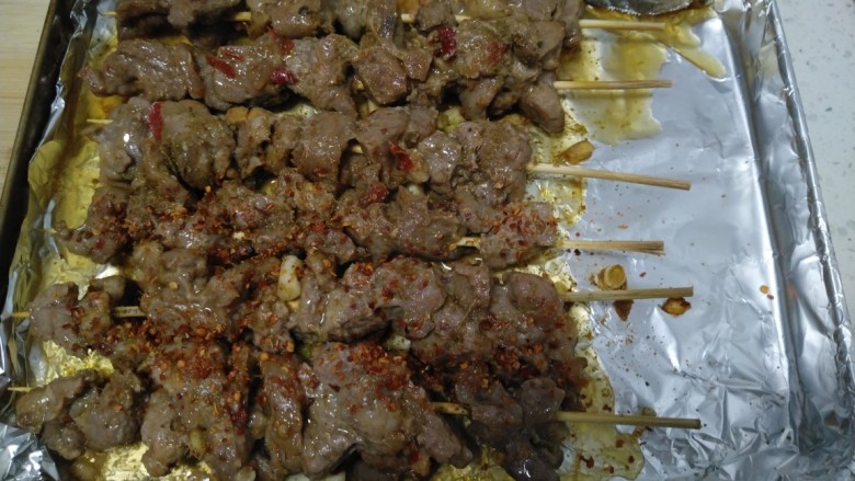 烤羊肉串,翻面再均匀抹上油,撒上孜然粉和<a style='color:red;display:inline-block;' href='/shicai/ 761'>辣椒粉</a>,230度再烤10分钟。