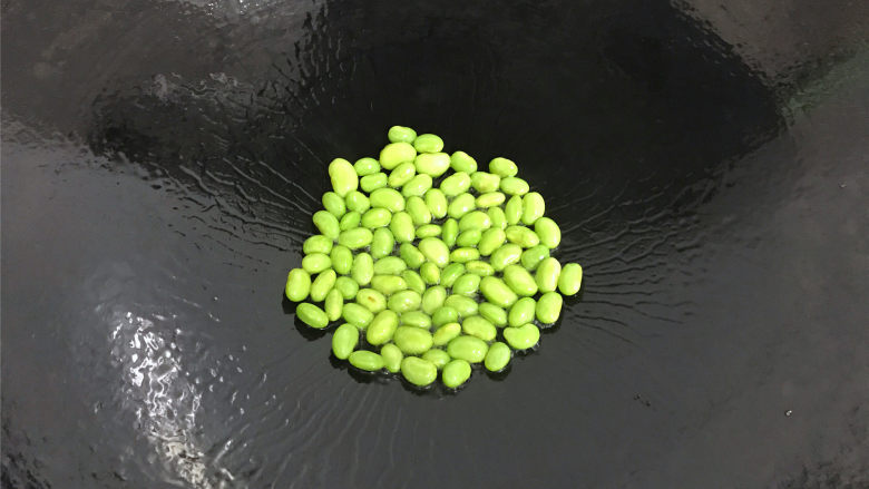 咖喱牛蛙,锅中倒入适量油,先把毛豆籽放入锅中煸炒至表皮起皱,变色后盛出。