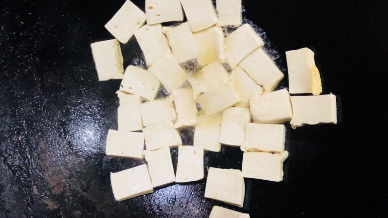 上海青炒豆腐,放入豆腐,摊平小火煎成金黄色