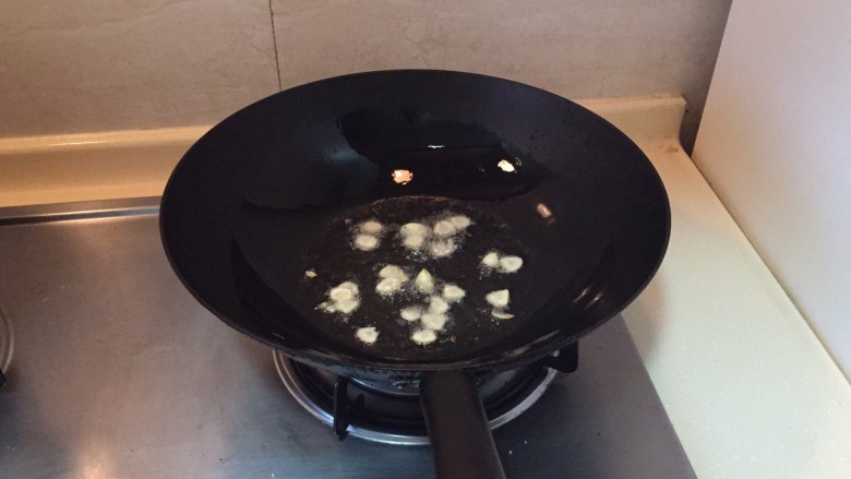 上汤娃娃菜,锅中倒入油,放入大蒜爆香。