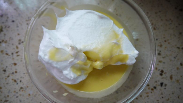 肉松小贝,把3分之1的蛋白霜加入到蛋黄糊中,用刮刀翻拌均匀,动作要快。翻拌就是用刮刀以写J字的方式,从2点的角度划到8点的角度,同时打蛋盆以逆时针的方向慢慢转动。