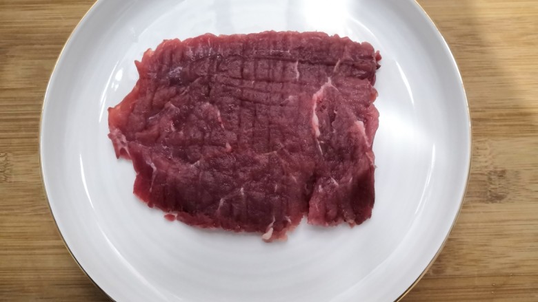 迷迭香黑胡椒牛排,敲好的牛肉,放入盘中