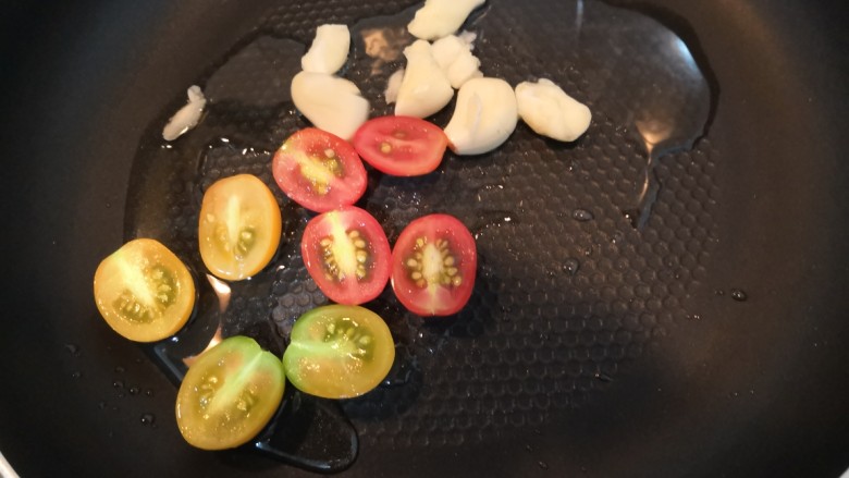 迷迭香黑胡椒牛排,油热,放入小番茄和蒜瓣,煎30秒
