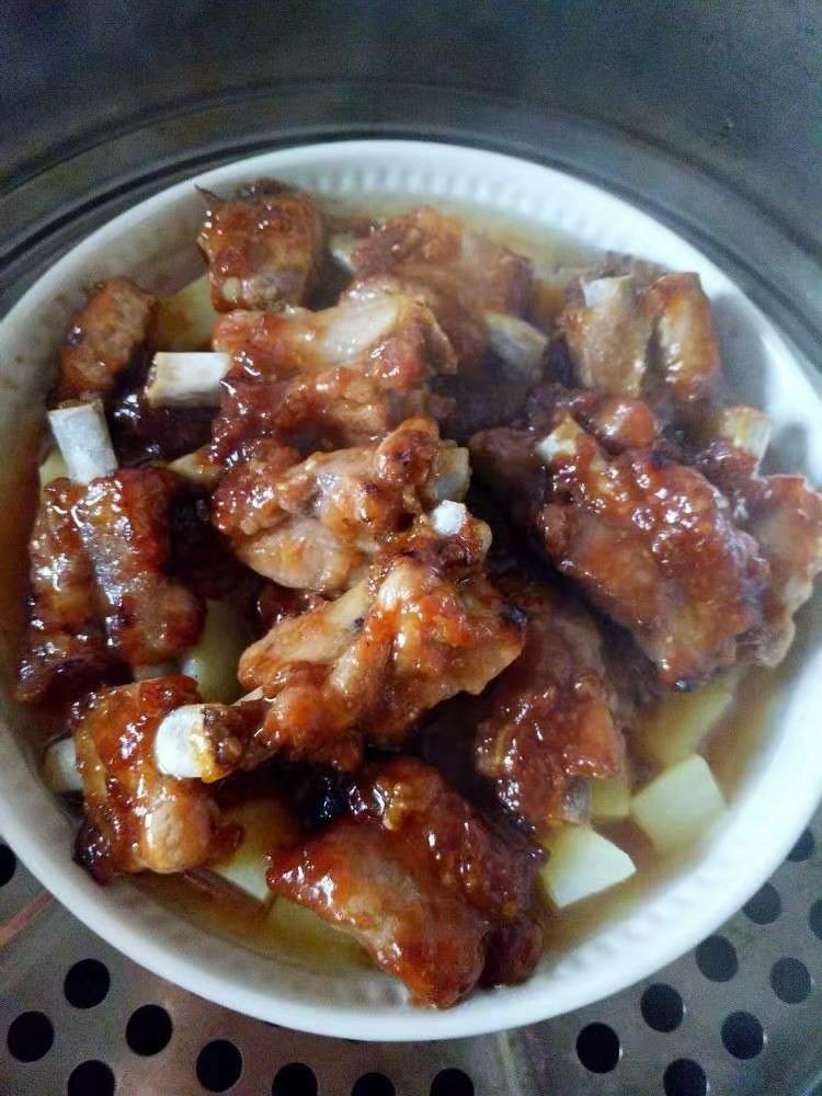 香酥排骨蒸土豆,蒸锅上汽后,上蒸锅隔水蒸25-30分钟,时间长一些,以便土豆熟透,同时使排骨更加酥烂,成功的作品,蒸到30分钟,会看到土豆浸泡在排骨的汤汁里,也就是说肯定会有汤汁,上图就是刚刚蒸好的。