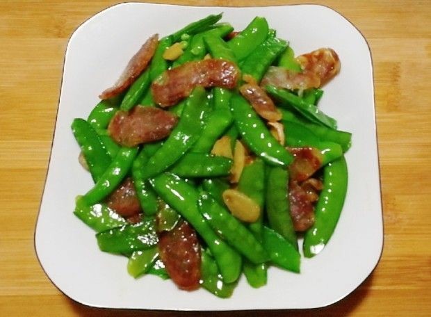 荷兰豆炒香肠,找个清爽的盘子装,颜色搭配很重要,任何一道菜根据颜色搭配,这样才能显示出菜肴的价值。