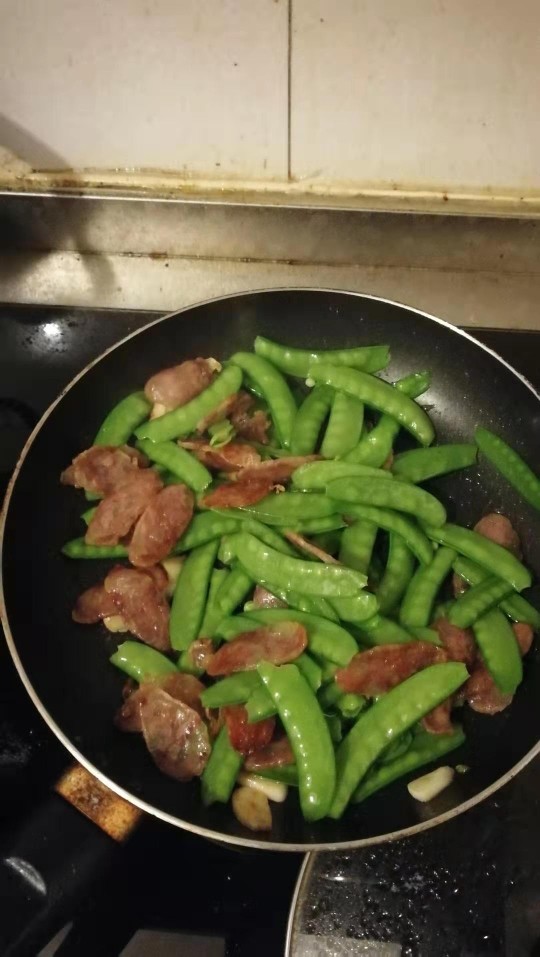 荷兰豆炒香肠,加入焯水过的荷兰豆,开大火快速翻炒两分钟,加入少许盐调味,再加入少许<a style='color:red;display:inline-block;' href='/shicai/ 10588'>糖</a>提鲜,关火,出锅