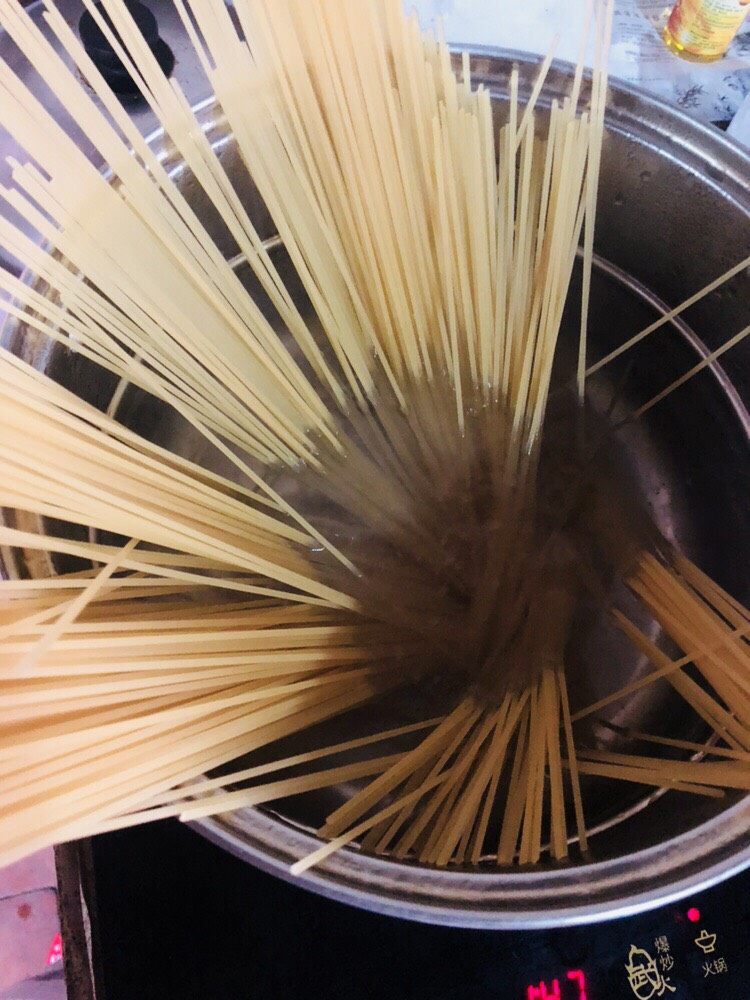 意大利面,锅内放入适量水烧开,放入意面。锅内加入适量盐和<a style='color:red;display:inline-block;' href='/shicai/ 851'>橄榄油</a>。意面煮软至断生。一般需要8-12分钟。这个空档用来做番茄肉酱